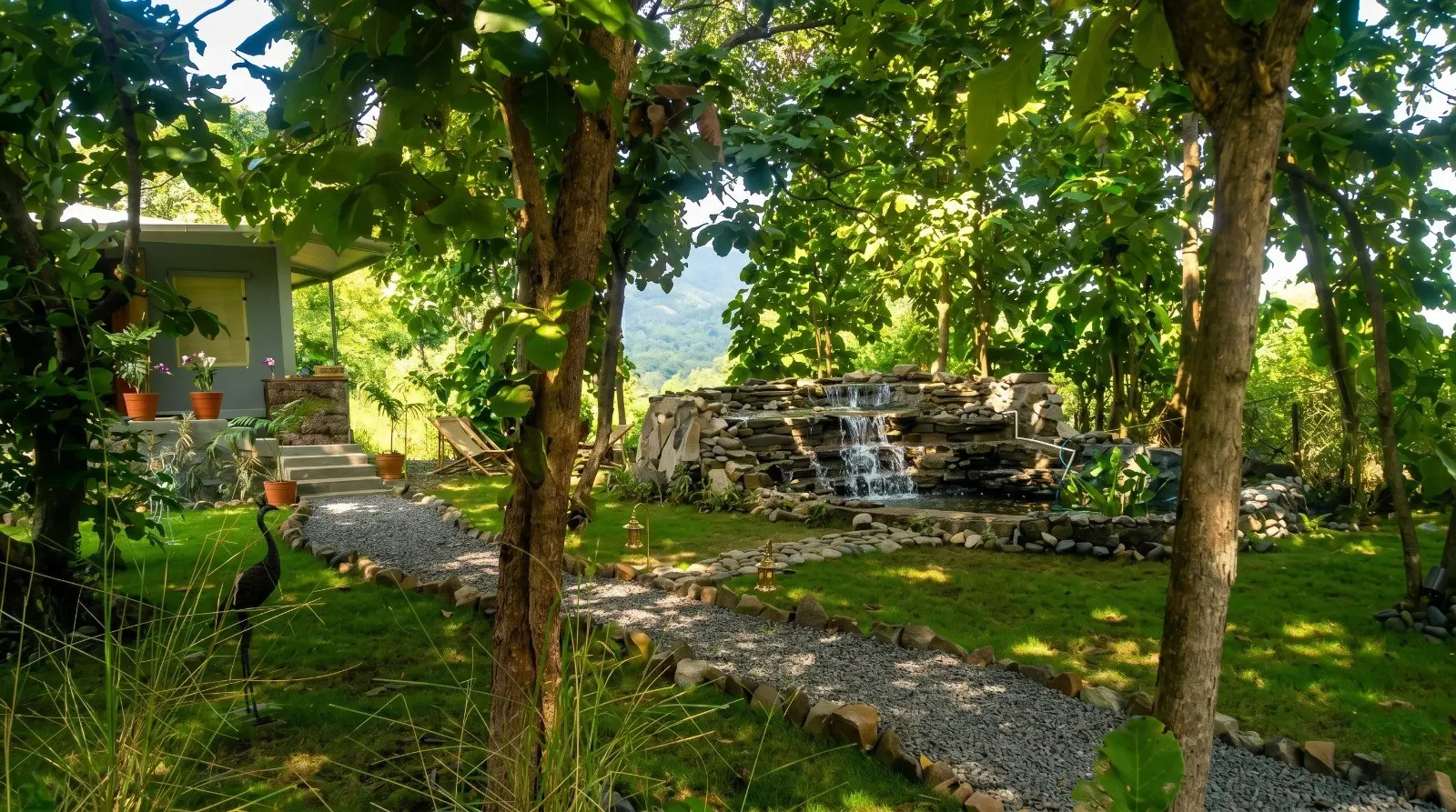 Wildlife Jungle Resort nature cottage with lush garden and small waterfall creating peaceful ambiance