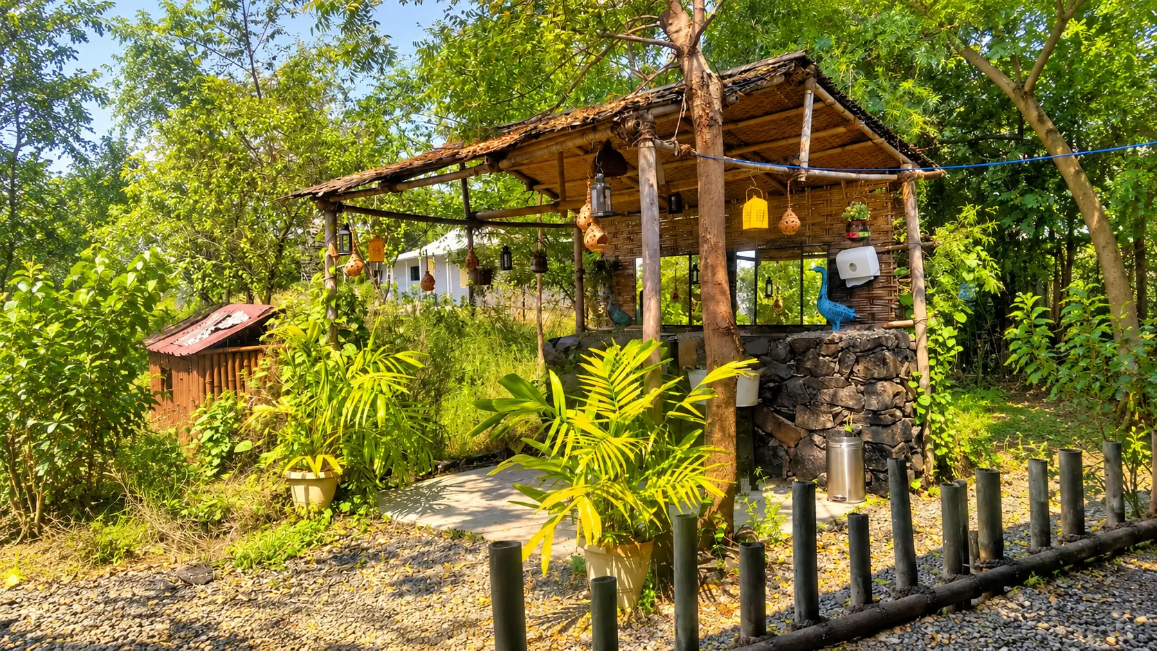 Rustic hut with a thatched roof in the garden of a jungle lodge